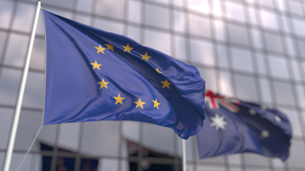 Waving,Flags,Of,The,Eu,And,Australia,Near,Modern,Skyscraper.