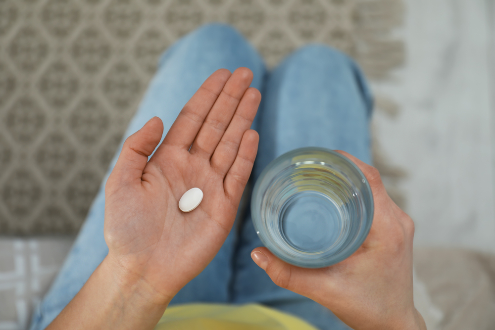 Young,Woman,With,Abortion,Pill,And,Glass,Of,Water,,Top