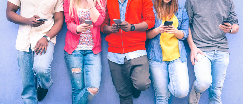 Teenagers,Texting,Mobile,Phone,Messages,Leaning,On,Urban,Wall,-