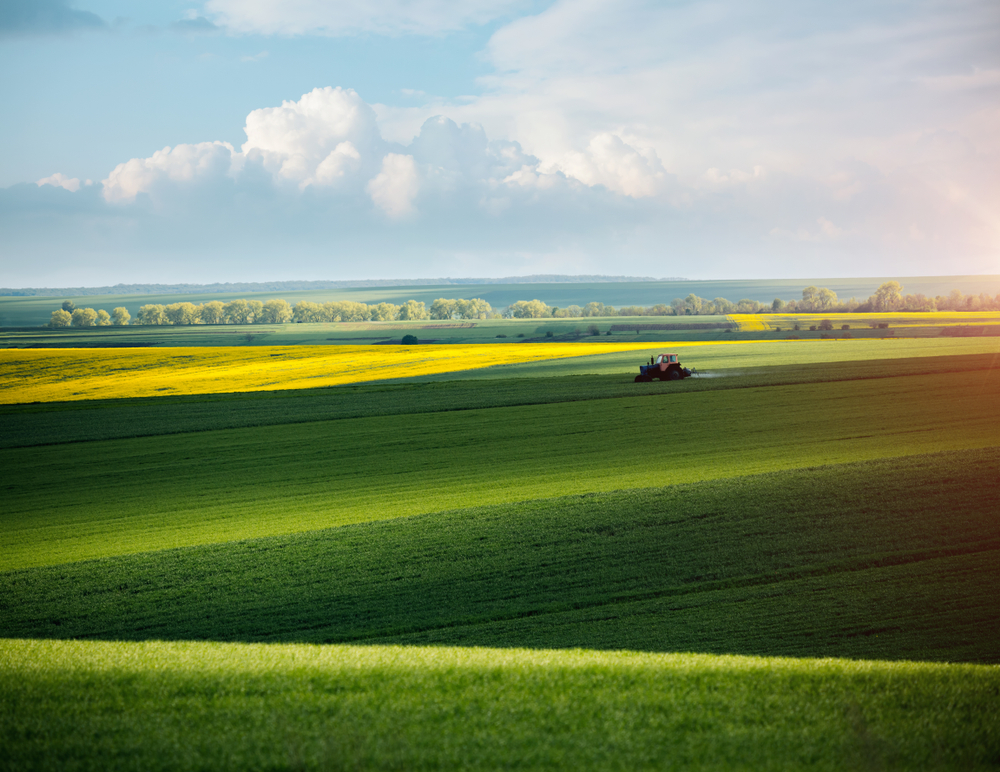 Tractor,Spraying,Pesticides,On,Soybean,Field,At,Springtime,On,A