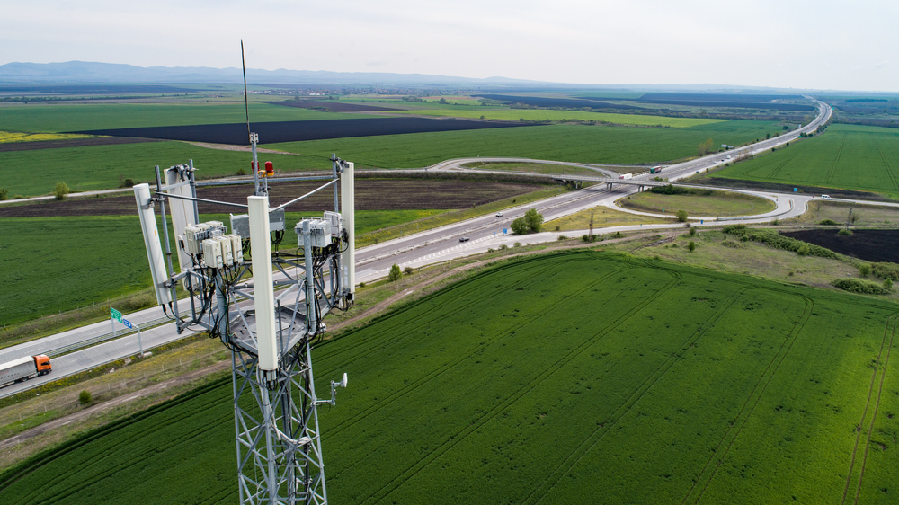 Aerial,Shot,Of,Telecommunication,Tower,With,Highway,On,The,Back.