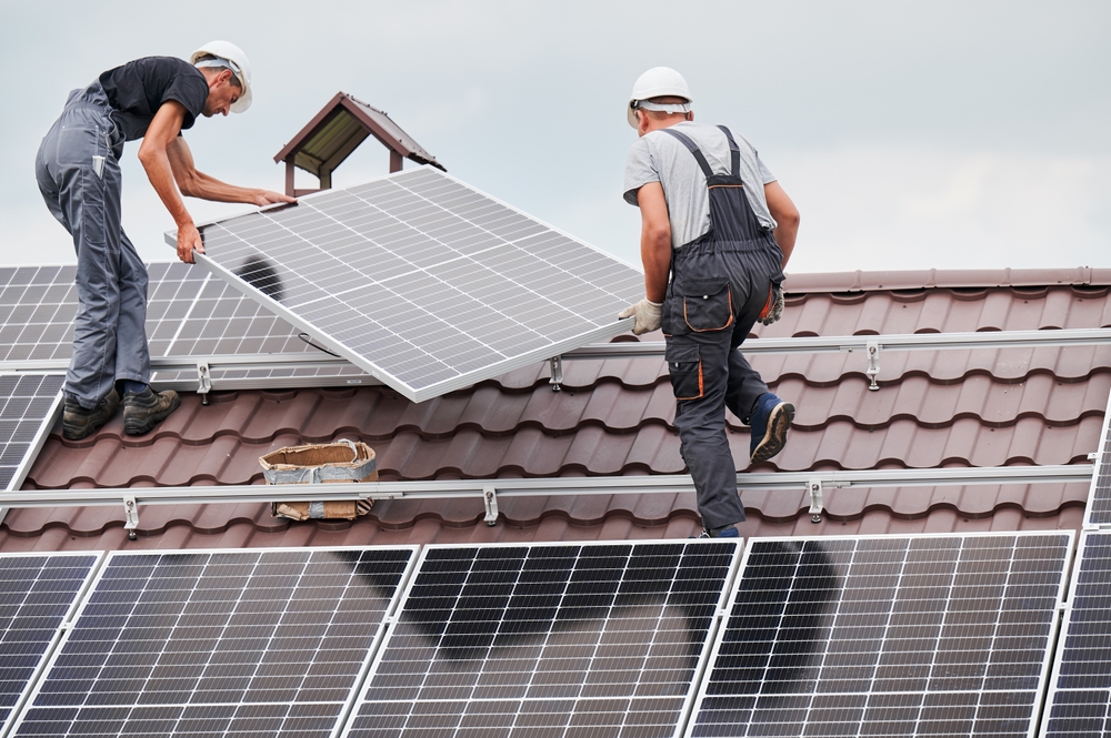 Men,Technicians,Lifting,Up,Photovoltaic,Solar,Moduls,On,Roof,Of