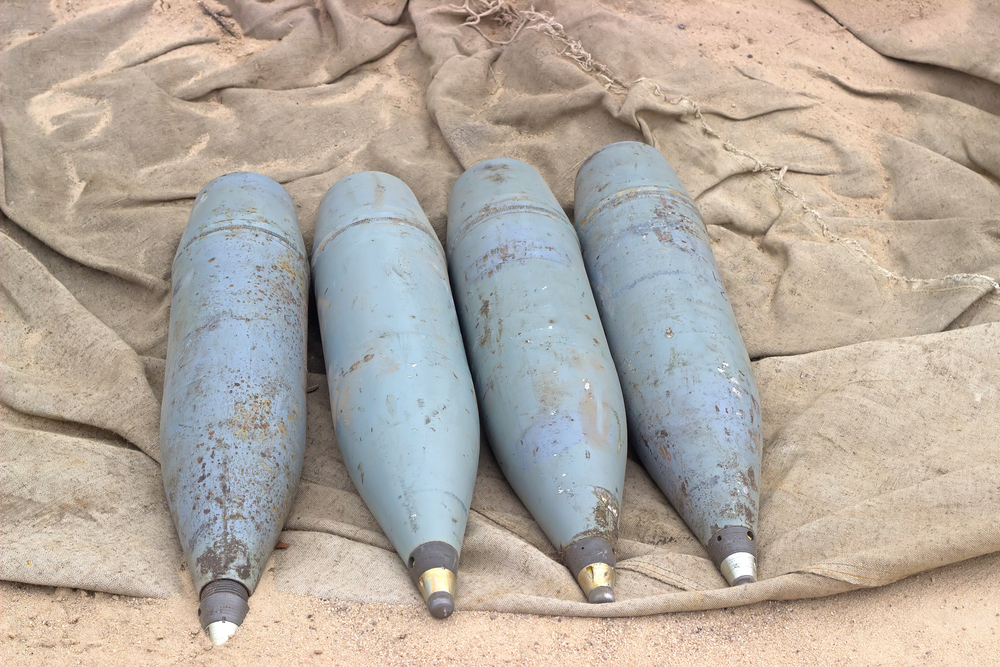 Four,Rusty,Artillery,Shells,On,The,Sand