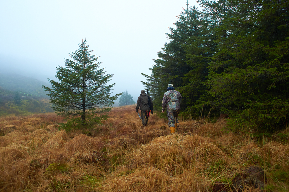 Two,Hunters,In,The,Forest,During,The,Day,With,Moss