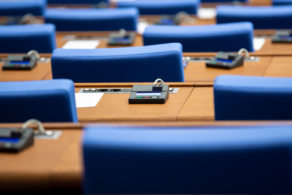 Inside,Of,An,Empty,Parliament,Hall.,Blue,Chairs,In,Line