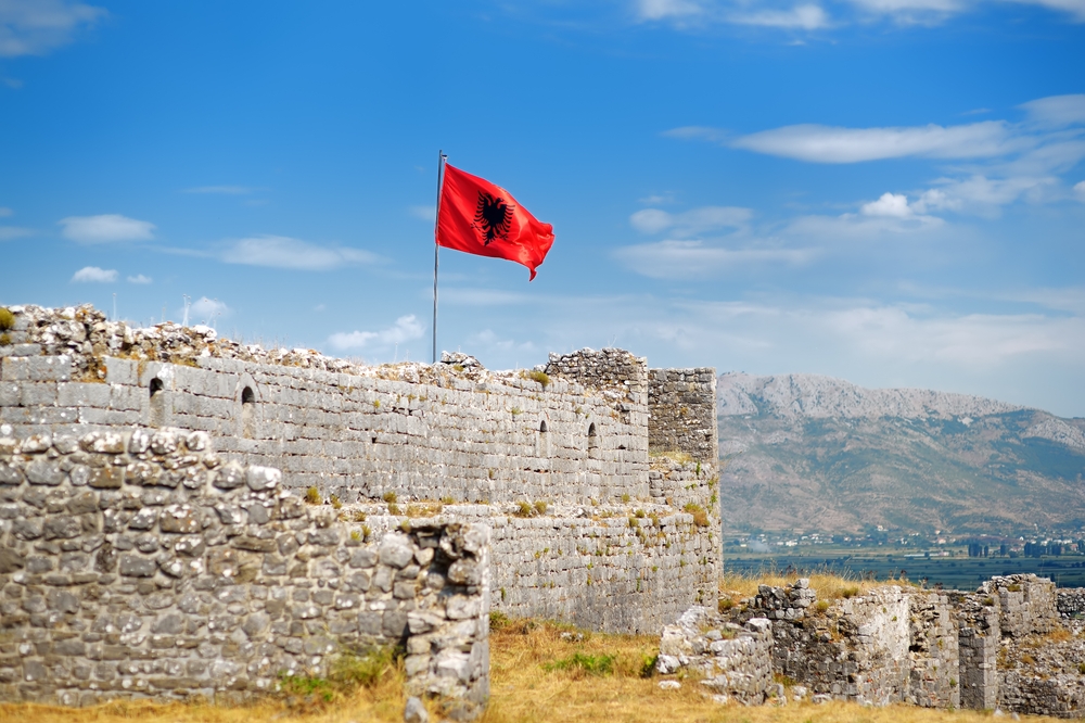 Red,Albanian,Flag,With,Double-headed,Black,Eagle,Waving,Over,Wall