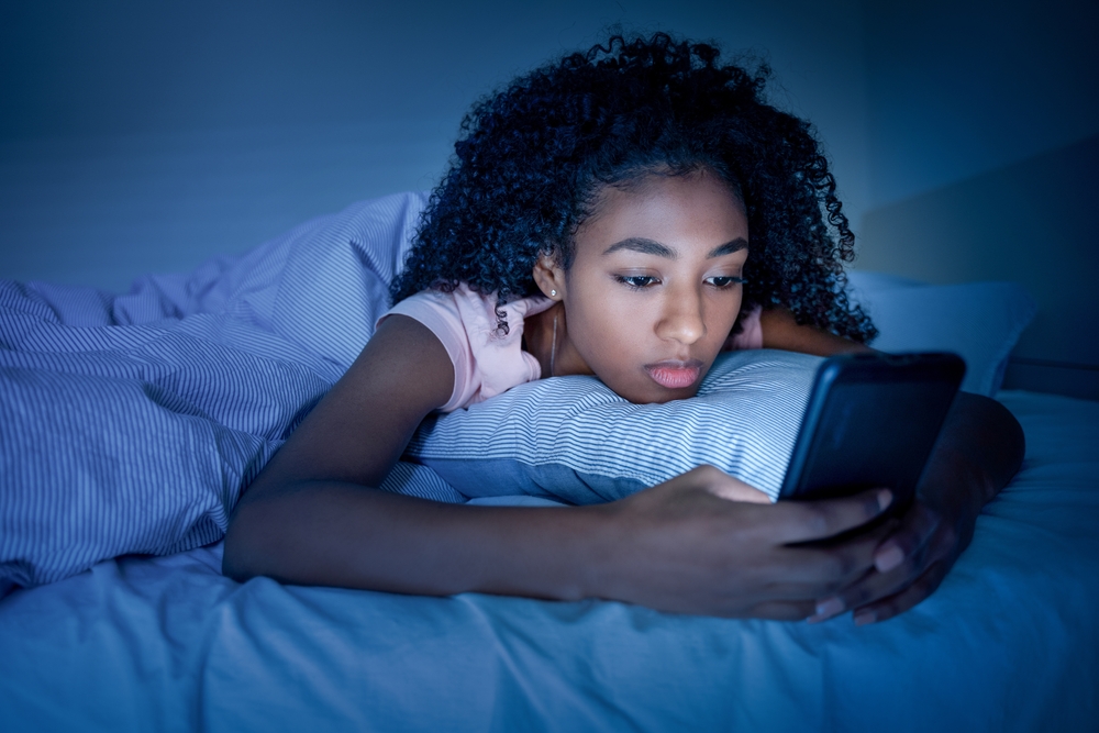 Black,Girl,Using,Smartphone,In,Bed,Before,Sleeping