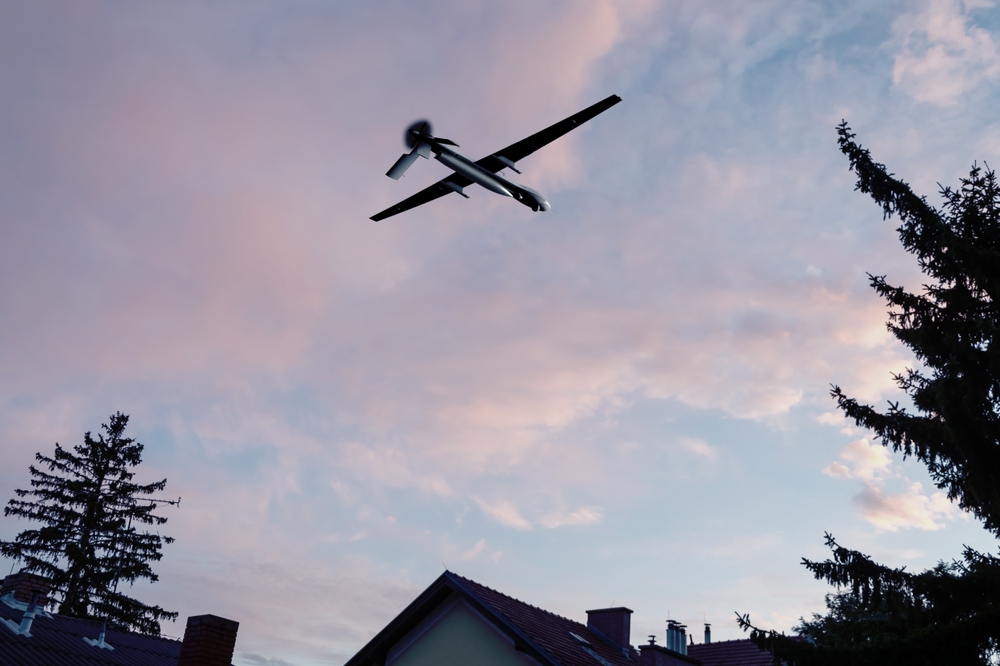 Unmanned,Military,Drone,Flying,In,The,Sky,Over,Residential,Buildings,
