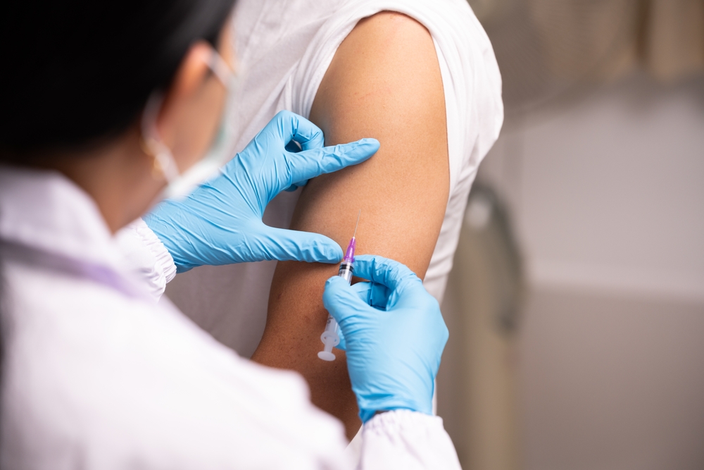 Doctor,Hand,In,Blue,Gloves,Holding,Influenza,Vaccine,For,Prevention