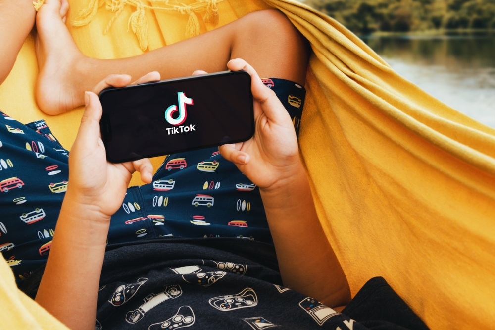 Child,Lying,In,Hammock,With,Tik,Tok,App,On,Smartphone