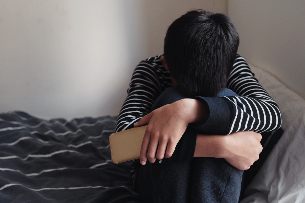 Young,Asian,Preteen,Teenager,Boy,Hugging,His,Knee,In,His
