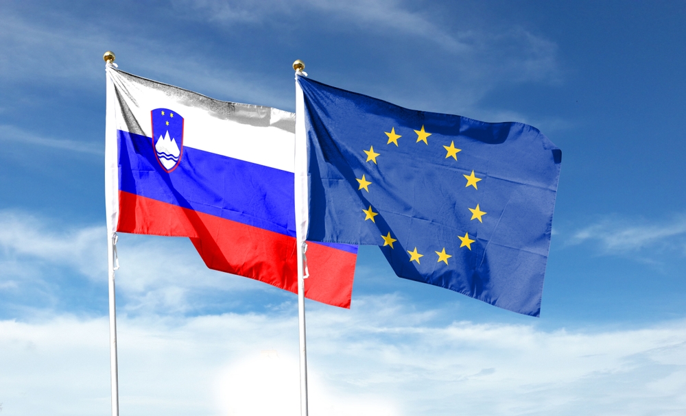 Slovenia,Flag,And,Eu,Flag,On,Cloudy,Sky.,Waving,In