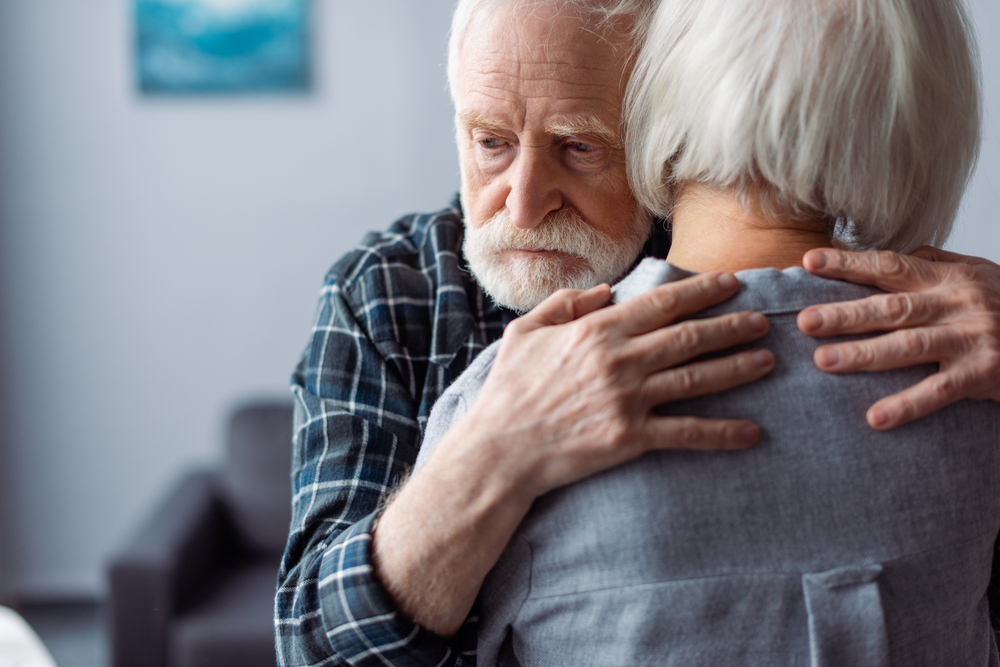 Back,View,Of,Senior,Woman,Hugged,By,Husband,,Sick,On