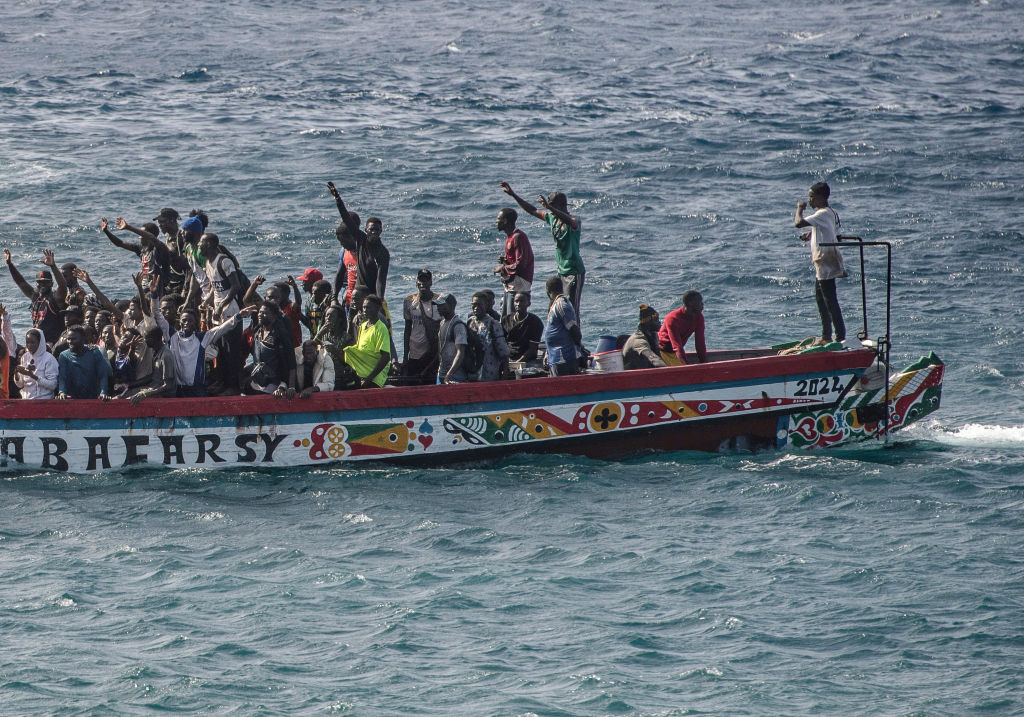 A group of migrants celebrates after being rescued at the