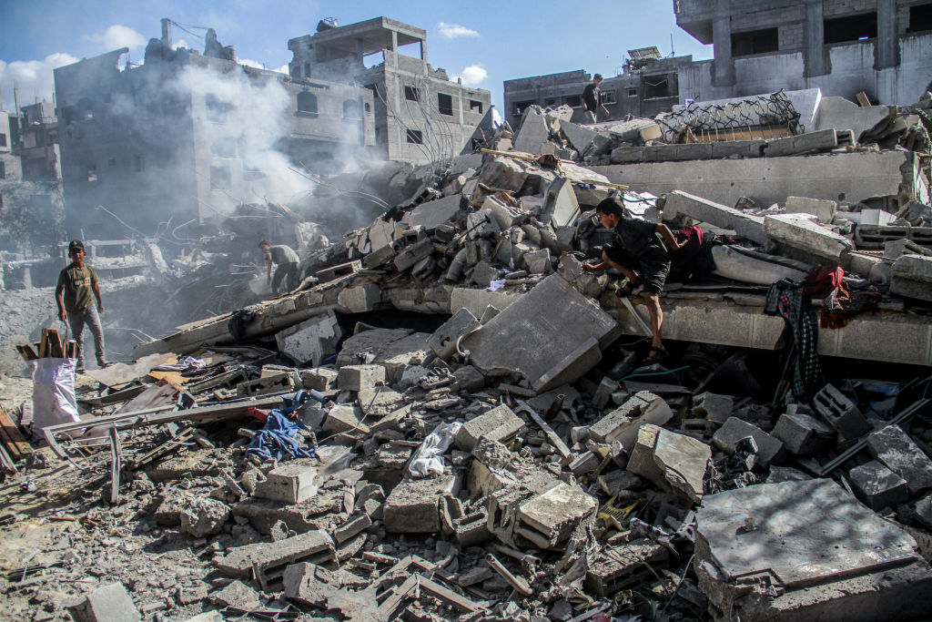Palestinians inspect their destroyed homes after the Israeli