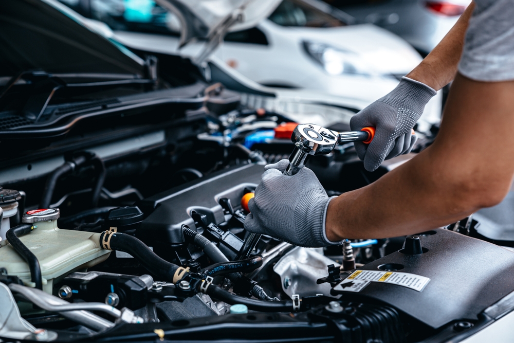Mechanic,Using,Wrench,While,Working,On,Car,Engine,At,Garage