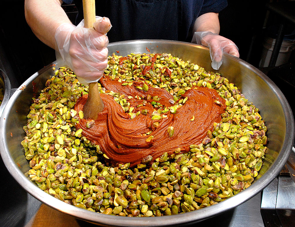 Neil Vanston stirs in the cayenne pepper, soy, and garlic flavoring that will enhance the pistachios
