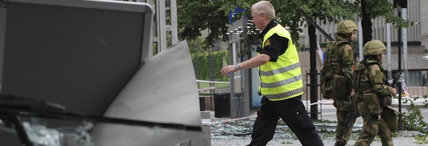 Ein Polizist und bewaffnete Soldaten gehen in der Innenstadt in Oslo an Trümmern vorbei. Bei dem Doppelanschlag in Norwegen sind nach Angaben der Polizei am 22. Juli 2011 mindestens 91 Menschen getötet worden. Foto: dpa
