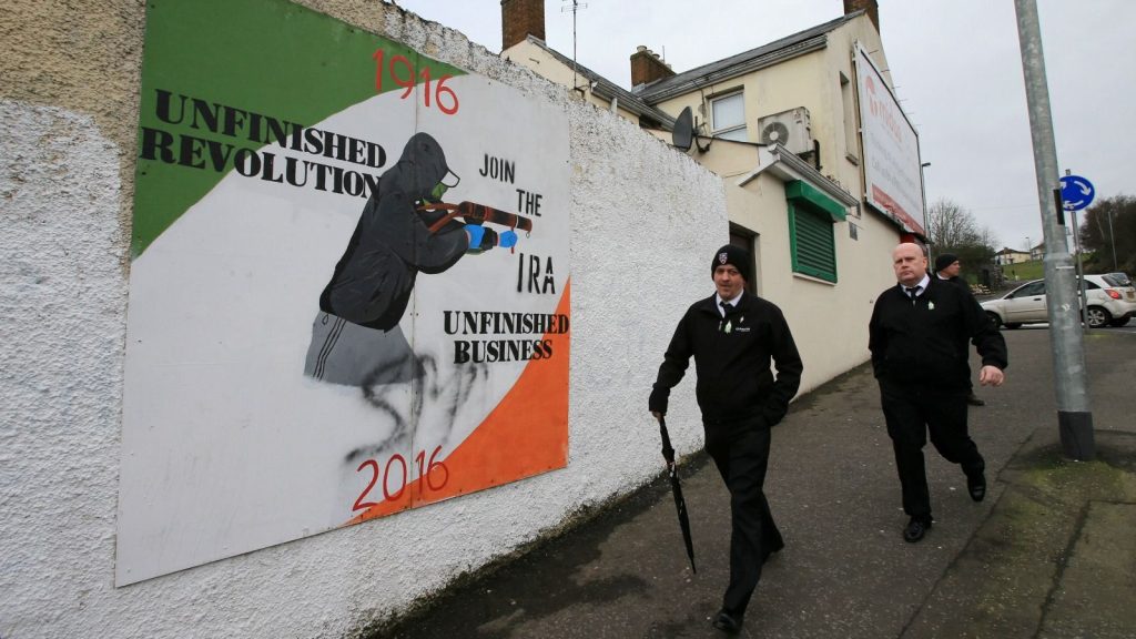 epa05865529 People walk pass a IRA mural in the Bogside area of Londonderry, Northern Ireland, 23 March 2017 ahead of the funeral of Sinn Féin’s Martin McGuinness. Sinn Fein’s Martin McGuinness, Northern Ireland’s former deputy first minister, died aged 66 on 21 March 2017. It is understood he had been suffering from a rare heart condition. The former IRA leader turned peacemaker worked at the heart of the power-sharing government following the 1998 Good Friday Agreement. He became deputy first minister in 2007, standing alongside Democratic Unionist Party leaders Ian Paisley, Peter Robinson and Arlene Foster.  EPA/PAUL MCERLANE