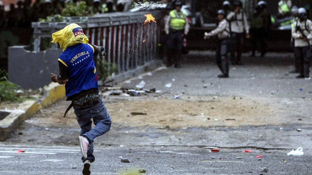 epaselect epa05918424 Demonstrators clash with members of the Bolivarian National Police as protests continue in Caracas, Venezuela, 20 April 2017. The Bolivarian National Police, using tear gas, tried to disperse protests against the government of Venezuelan President Nicolas Maduro.  EPA/Cristian Hernandez