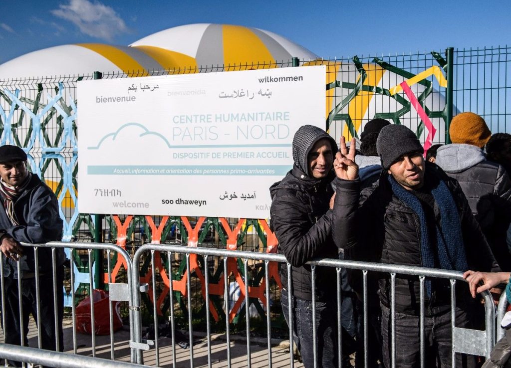 epa05627217 People wait outside the newly opened center for migrants and refugees at Porte de la Chapelle in Paris, France, 11 November 2016. The migrants were brought to the new centre after the so-called ‚Jungle‘ camp at Calais was dismantled in late October. The inhabitants of the migrant and refugee camp at Calais were relocated to dozens of centres and shelters across France.  EPA/CHRISTOPHE PETIT TESSON