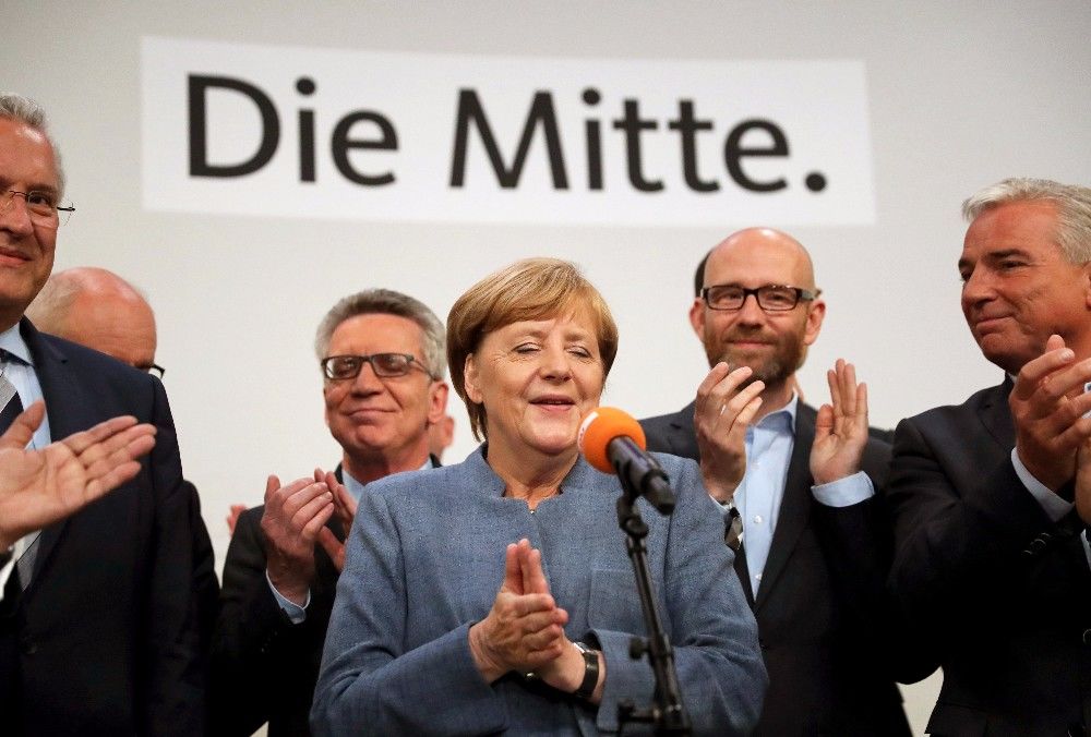 epaselect epa06225006 German Chancellor Angela Merkel (C) of the Christian Democratic Union (CDU) speaks to her supporters late in the evening at the CDU election event in Berlin, Germany, 24 September 2017. According to federal election commissioner more than 61 million people were eligible to vote in the elections for a new federal parliament, the Bundestag, in Germany.  EPA-EFE/CARSTEN KOALL