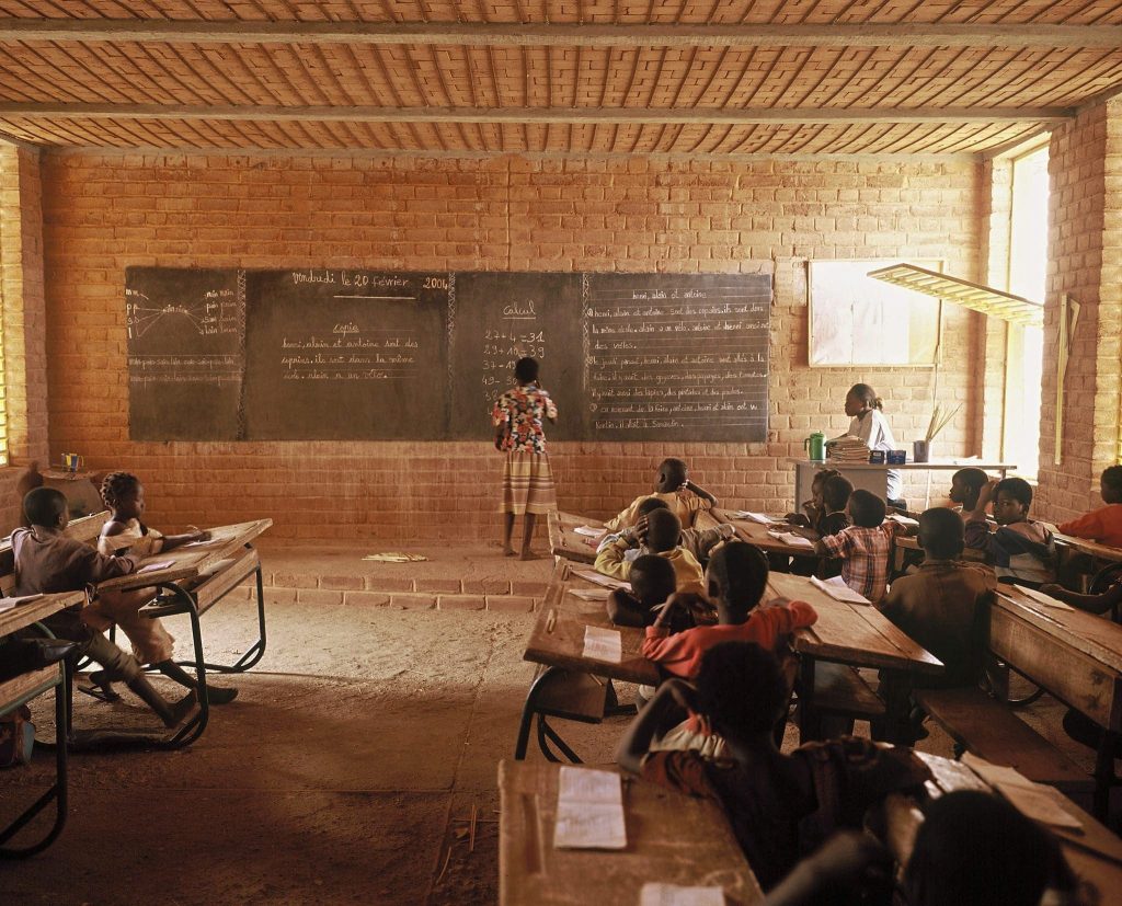 Children sit inside a classroom in an innovative school design in Gando