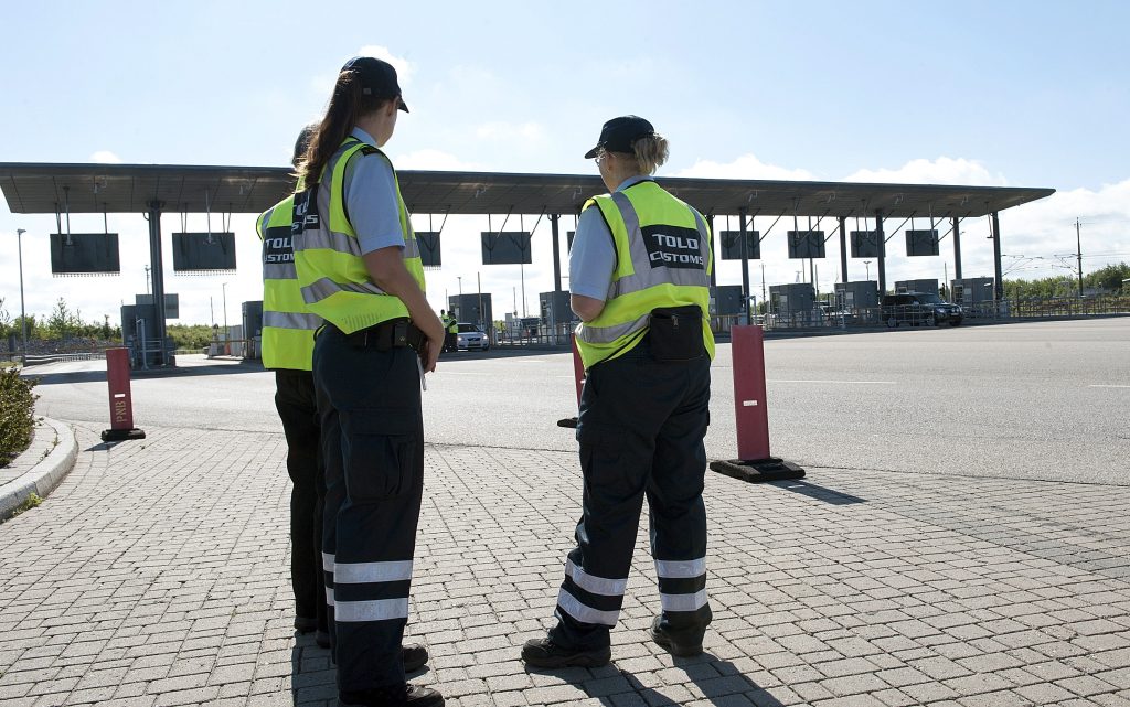 Danish custom officers stand at the Oeresund Bridge border control between Denmark and Sweden