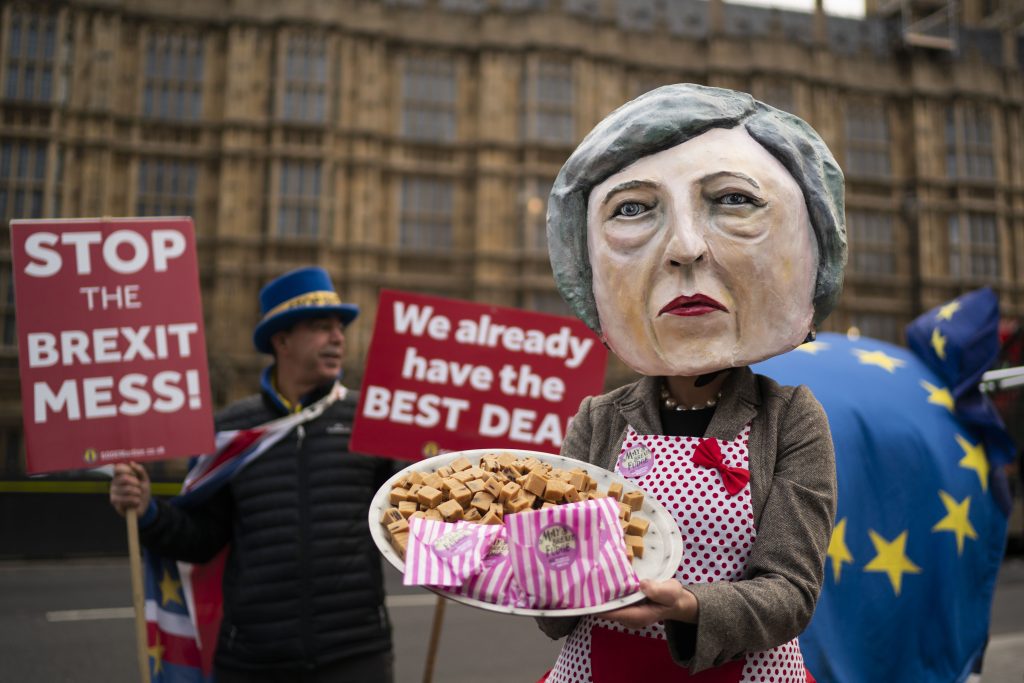 Campaigners pose as British Prime Minister Theresa May with a plate of fudge