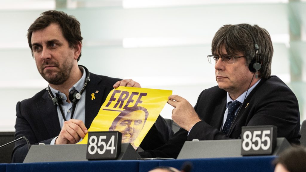 epa08125251 Former members of the Catalan government Toni Comin (L) and Carles Puigdemont (R) attend their  first plenary session as member of the European Parliament in Strasbourg, France, 13 January 2020 and hold a poster with jailed Catalan politician Oriol Junqueras.  EPA-EFE/PATRICK SEEGER