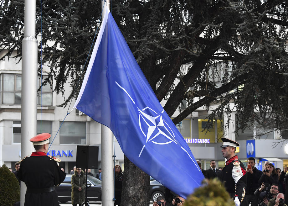 Members of the honor guard raise the NATO flag in front of North Macedonia’s parliament