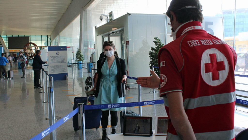 epa08462150 An aiport employee wears a Smart-Helmet with a portable thermoscanner to screen passengers arriving at Terminal 3 at Leonardo Da Vinci airport after the reopening of regional borders amid an easing of restrictions during Phase 2 of the coronavirus emergency, in Fiumicino, Italy, 03 June 2020.  EPA-EFE/REDAZIONE TELENEWS