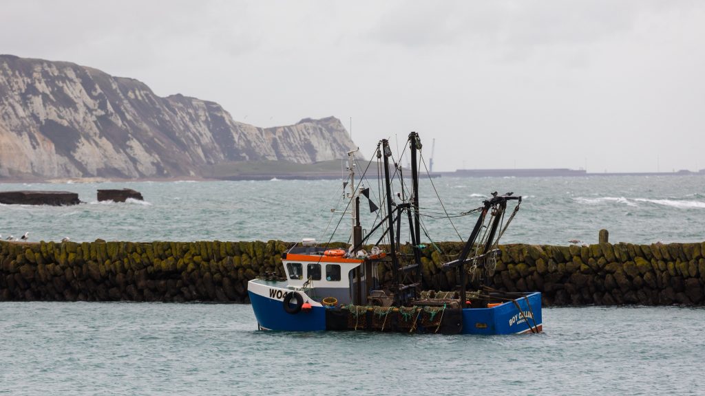 epa08881427 A fishing boat with the white cliffs of Dover in the background seen in the harbour in Folkestone, Kent, Britain, 13 December 2020. EU Commission President, Ursula von der Leyen and British Prime Minister Boris Johnson have announced on 13 December that they have mandated negotiators to continue Brexit talks to see if an agreement can be reached.  EPA-EFE/VICKIE FLORES