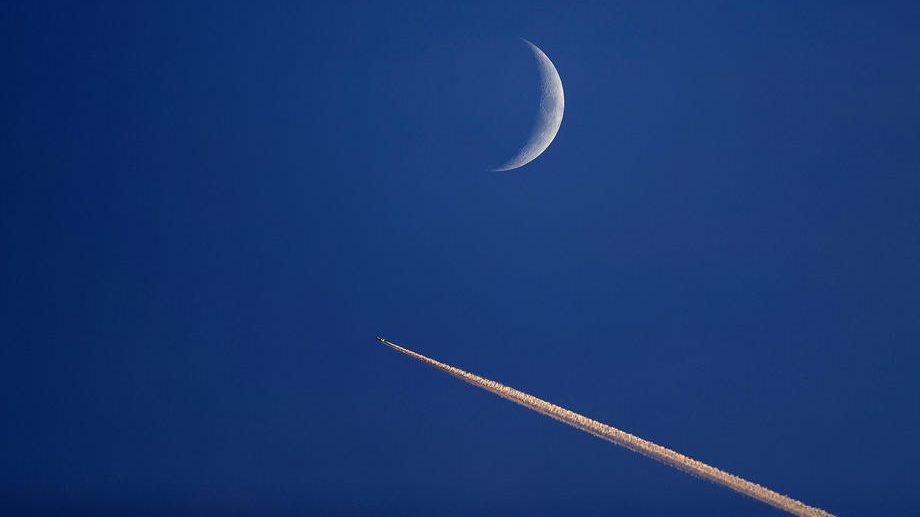 Airplane passes the moon in Germany