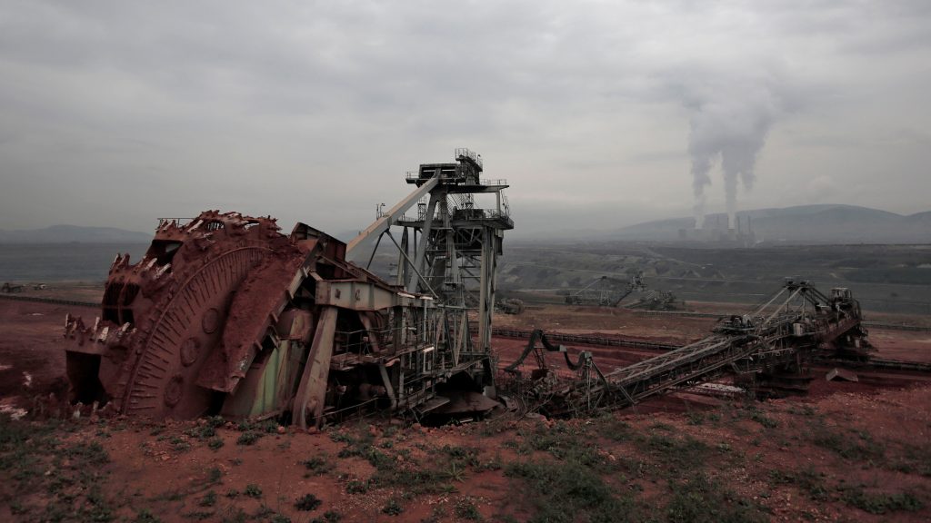 epa04480162 A picture made available on 07 November 2014 shows a huge excavator on operation as smoke rises from a power plant in the background, at the lignite center of Western Macedonia, near the city of Ptolemaida, northern Greece, 03 October 2014. Lignite is considered the black gold of Greece and accounts for 30 percent of the country’s energy supply. Eighteen power plants of total capacity of 4.388 MW, producing 52.1 percent of the country’s electricity, operate in the center, which extends from the city of Florina to the city of Ptolemaida in western Macedonia region where entire villages such as Charavgi, Klitos and Komanos were expropriated and their inhabitants removed so that the mines could be extended.  EPA/YANNIS KOLESIDIS