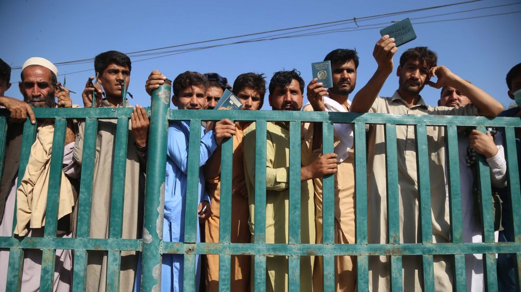 epa08761493 Afghans wait to apply for a visa at the Pakistani consulate after a stampede, in Jalalabad, Afghanistan, 21 October 2020. At least 11 people were killed and 13 injured in a stampede on a football ground where thousands had gathered to secure Pakistani visas in eastern Nangarhar province of Afghanistan. Most of the Afghans who apply for Pakistani visas are either visiting Pakistan for medical treatment or to visit their relatives and families as millions of Afghans have settled in the neighboring country since the last four decades of the conflict.  EPA-EFE/GHULAMULLAH HABIBI