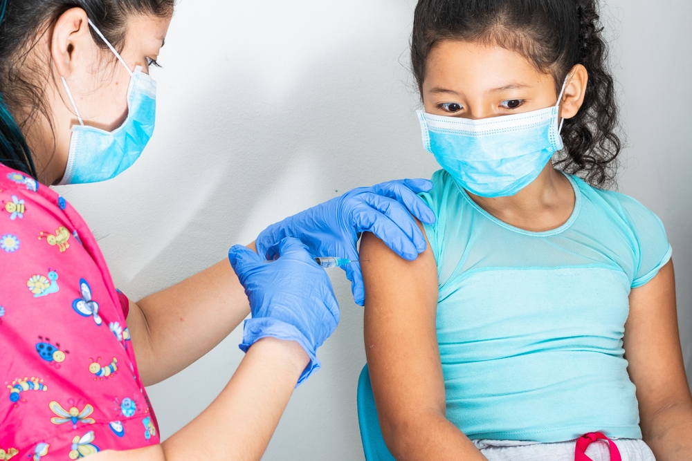 Children’s,Nurse,Injecting,Brown,Girl’s,Arm.,Girl,Distracted,While,Being