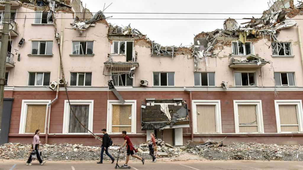 epa10030229 People walk near the remains of hotel Ukraine, destroyed in a Russian missile strike in Chernihiv city, Ukraine, 23 June 2022. On 24 February Russian troops entered Ukrainian territory starting a conflict that has provoked destruction and a humanitarian crisis.  EPA-EFE/OLEG PETRASYUK