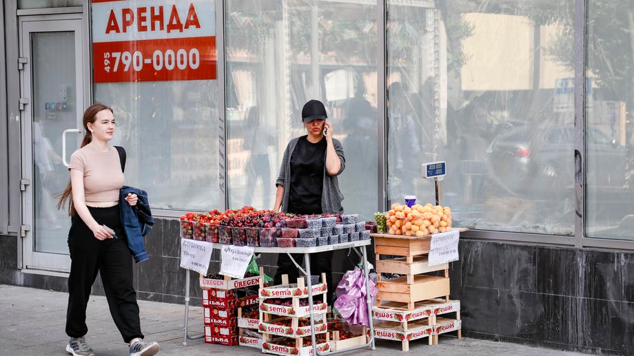 epa10065356 A woman sells fruit on the street in front of the empty commercial space with a ‚For rent‘ sign in the window in Moscow, Russia, 11 July 2022. The departure of international companies from Russia, which formed a third of the demand for office space in Moscow, could provoke a serious decline in Moscow’s business center market. Expected, by the end of 2022, 800 thousand square meters will be vacated in this segment.  EPA-EFE/YURI KOCHETKOV