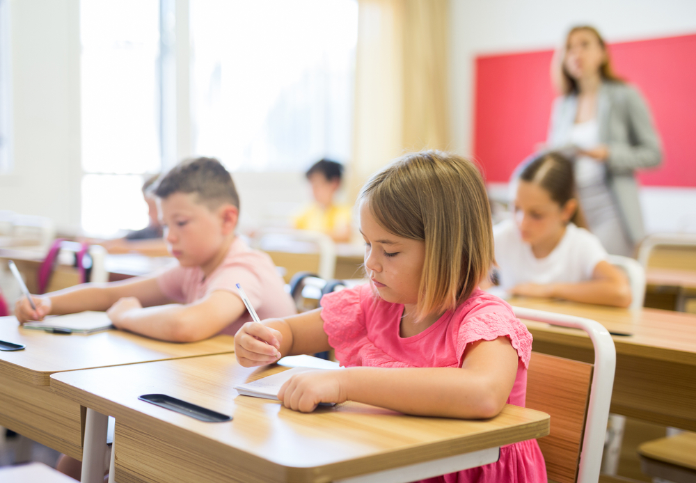 Portrait,Of,Cute,Intelligent,Schoolgirl,Who,Writing,Exercises,At,Lesson