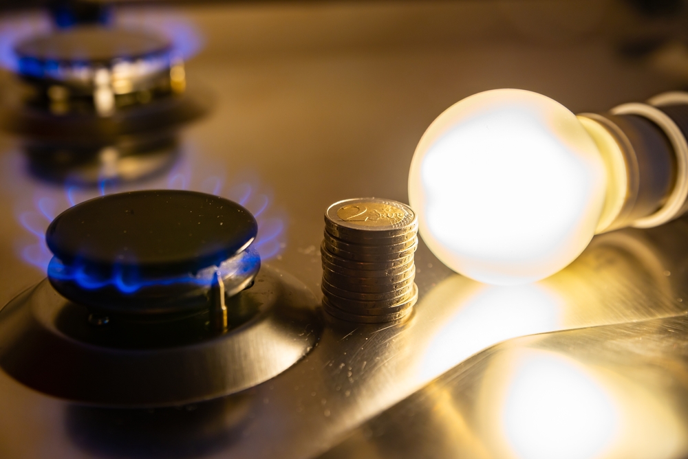 Light,Bulb,On,Next,To,Lit,Gas,Cooker,,With,Coins