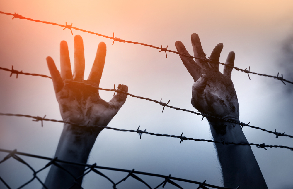 Refugee,Men,And,Fence.,Refugee,Concept