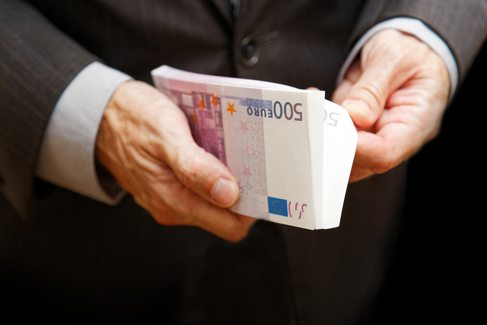 A,Man,Counts,The,Money,In,A,Bundle,Of,Banknotes