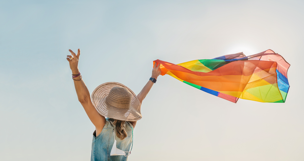 Woman,Waves,A,Pride,Flag,With,Rainbow,Colors.,Concept,Of