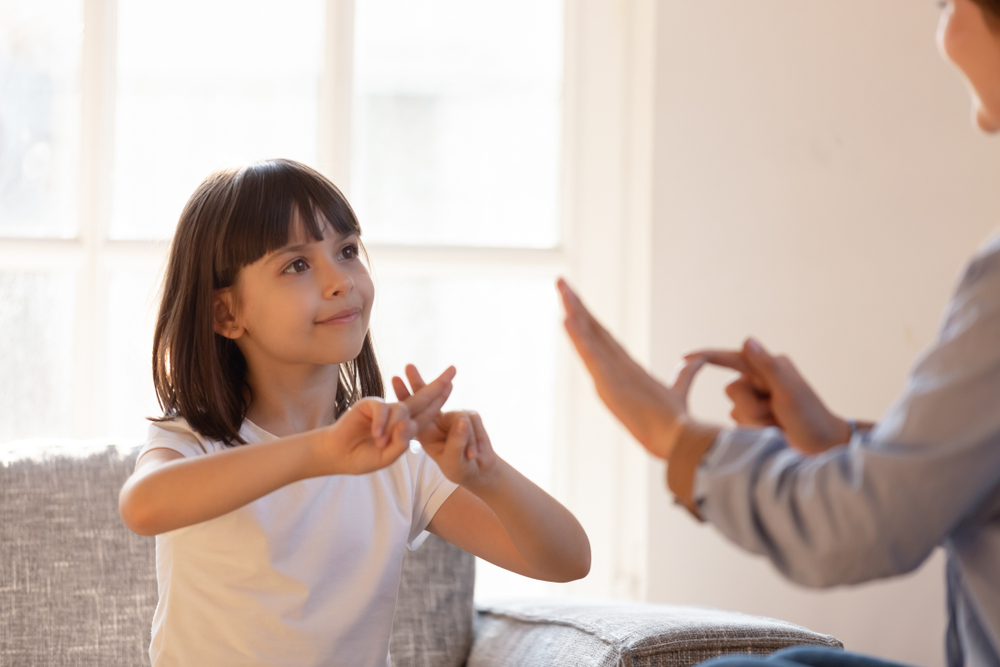Mom,Communicating,With,Deaf,Daughter,Focus,On,Kid,Sitting,On