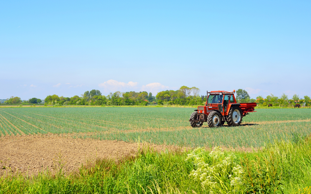 Red,Tractor,Working,On,A,Plowed,Country,Field,In,The