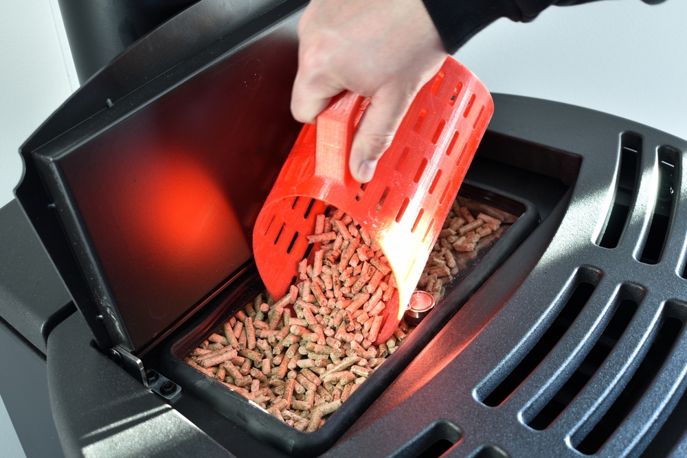 Close-up,On,Pellets,,Black,Domestic,Pellet,Stove,,Man,Loading,By
