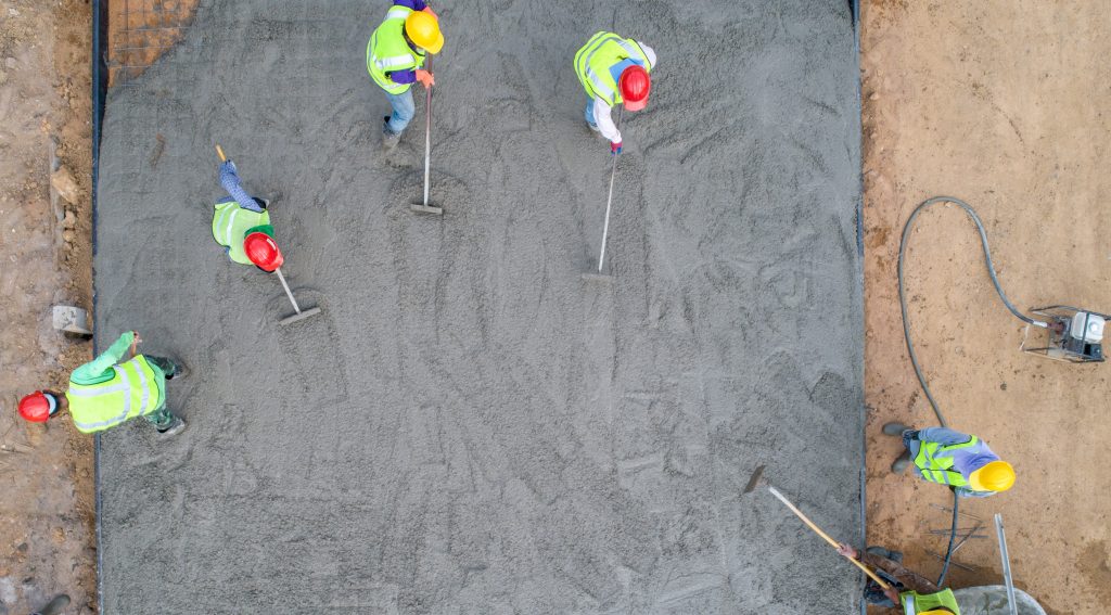 A,Construction,Worker,Pouring,A,Wet,Concret,At,Road,Construction