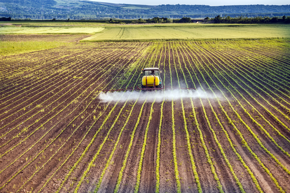 Tractor,Spraying,A,Field,Of,Corn