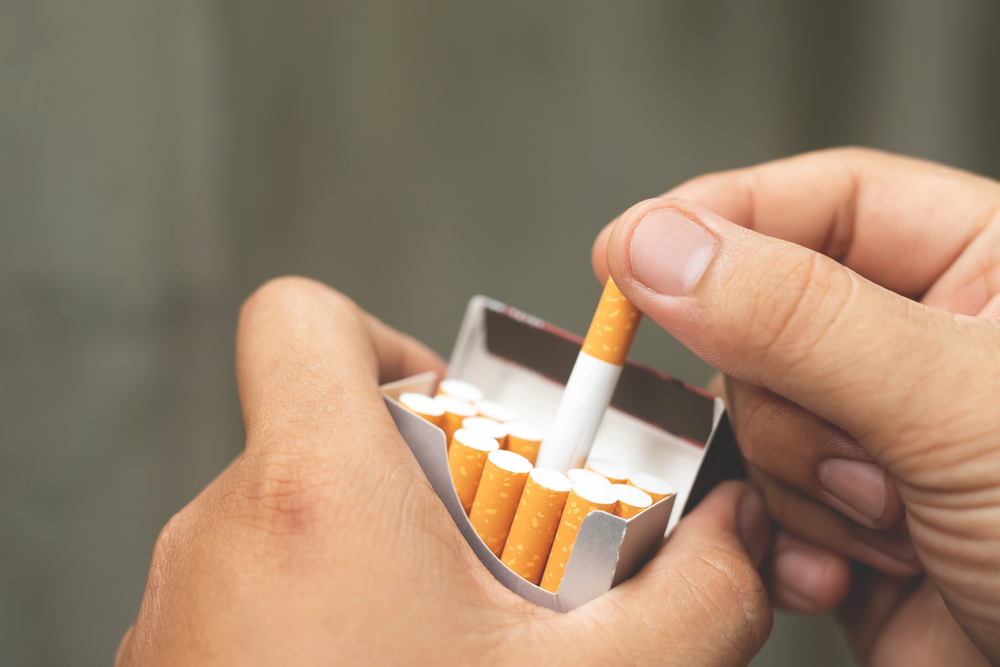 Man,Holding,Cigarette,In,Hand,And,Smoking